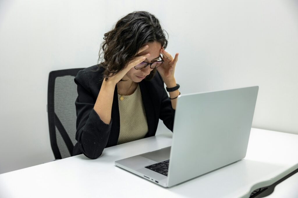 Gefrustreerde medewerker achter een laptop door te veel controle.