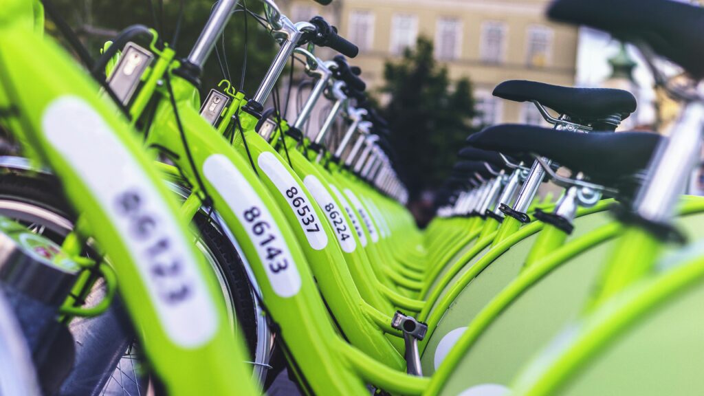 Een rij groene deelfietsen, symbool voor mobiliteit-as-a-service en de verschuiving van bezit naar toegang.
