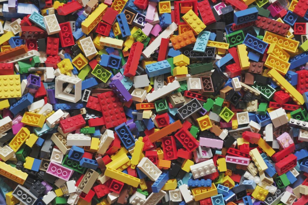 Een stapel kleurrijke Lego-blokjes, symbool voor de basis en creativiteit van Lego’s succes.